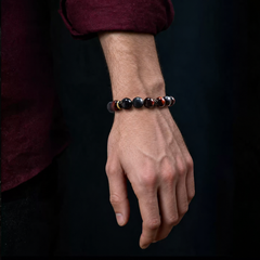 Red and black stone bracelet worn on the wrist with a dark burgundy sleeve