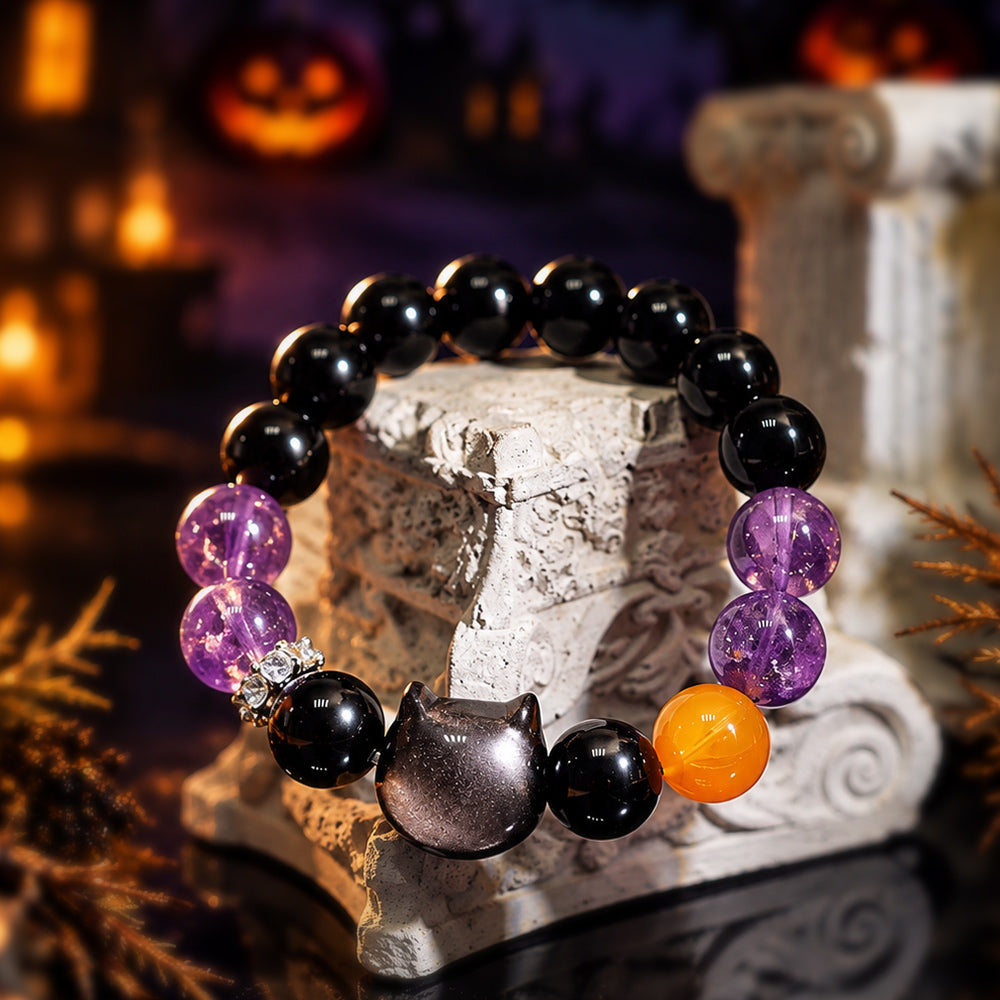 Obsidian cat and amethyst bracelet styled in a candlelit Halloween scene