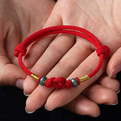Red String and Lucky Jade Bead Bracelet, a meaningful charm bracelet for good luck, protection, and positive energy.