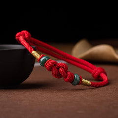 Red String and Lucky Jade Bead Bracelet, a meaningful charm bracelet for good luck, protection, and positive energy.