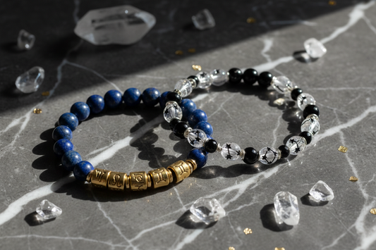 Two handcrafted energy bracelets with blue lapis lazuli and clear quartz on a marble surface