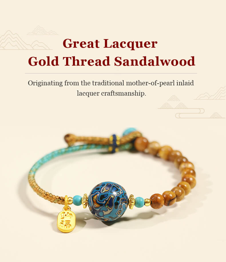 Handcrafted energy bracelet with sandalwood beads, a blue lacquer bead, and gold charm.