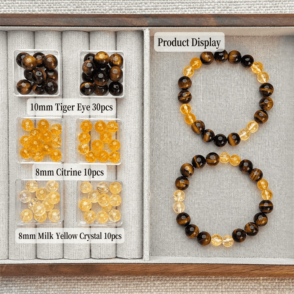 Handcrafted tiger eye, citrine, and yellow crystal energy bracelets in a wooden display tray.