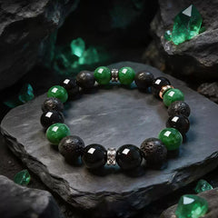 Green and black 10 mm beaded bracelet displayed on a dark stone surface