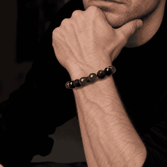 Unisex green and black beaded bracelet worn on a wrist against a dark background