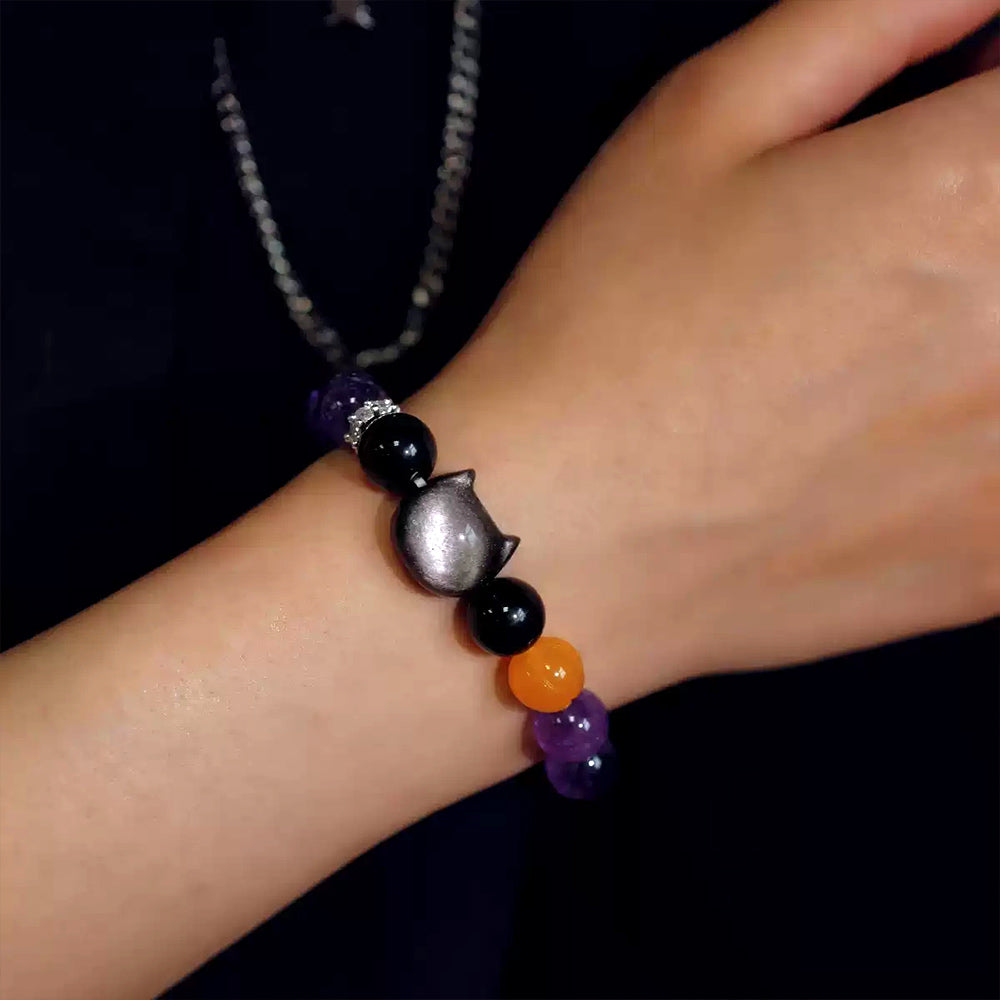Witchy amethyst and obsidian cat bracelet shown from the side on the wrist