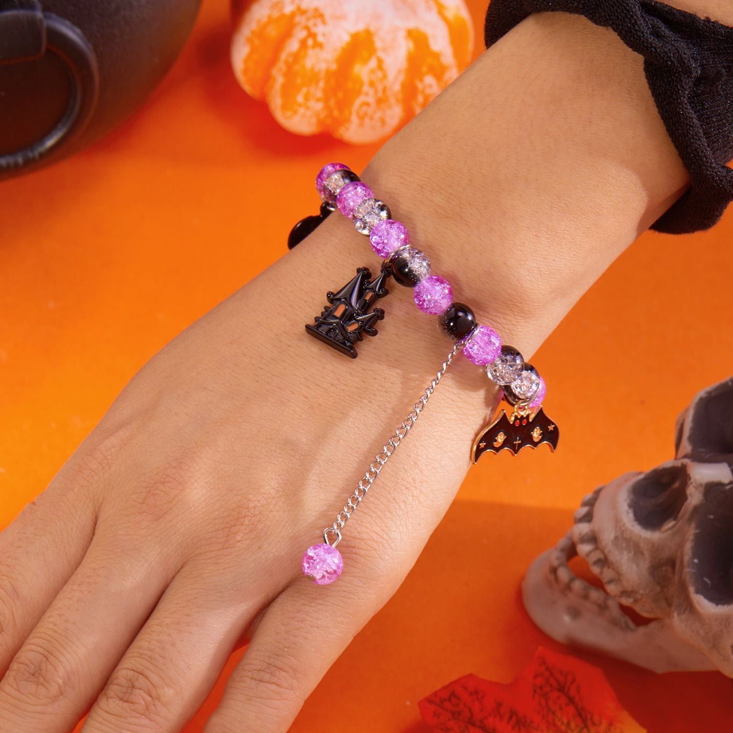 Close-up of purple crackle-effect beads with haunted house, bat and chain-drop details