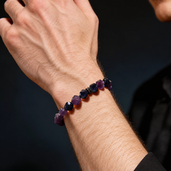 Purple and dark-blue faceted stretch bracelet worn on a wrist with a black sleeve
