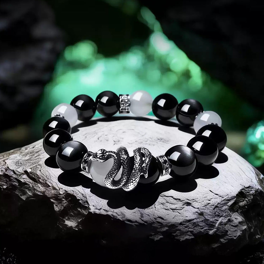 White agate and silver sheen obsidian snake bracelet displayed on a dark stone surface