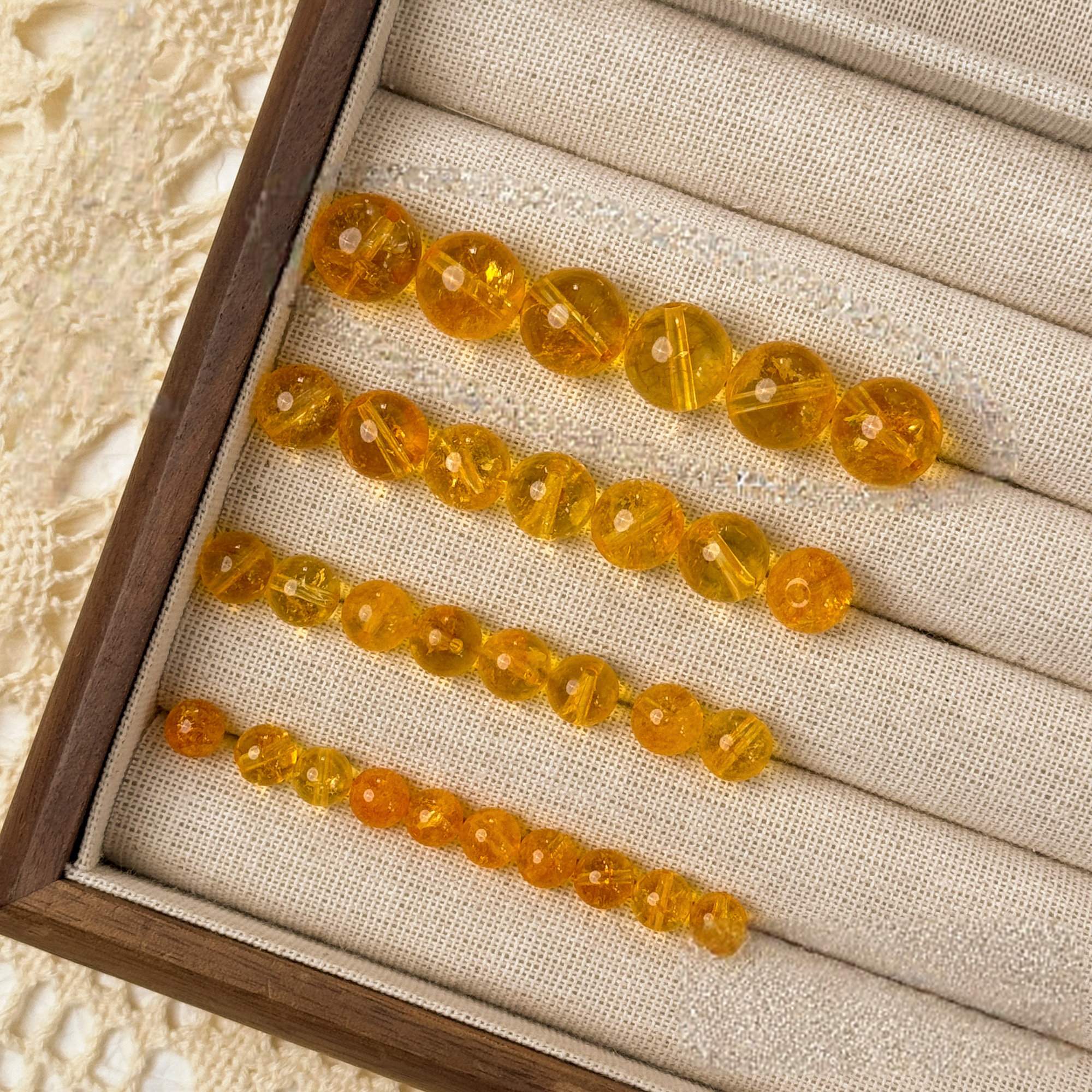 Handcrafted amber energy bead bracelets in a wooden jewelry display box.